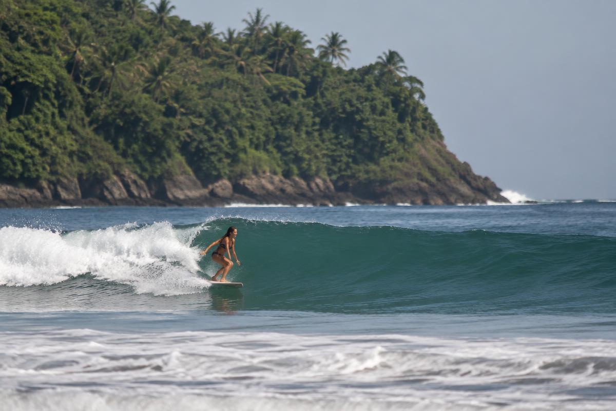 Surfer walking to the water with a board in Punta de Mita